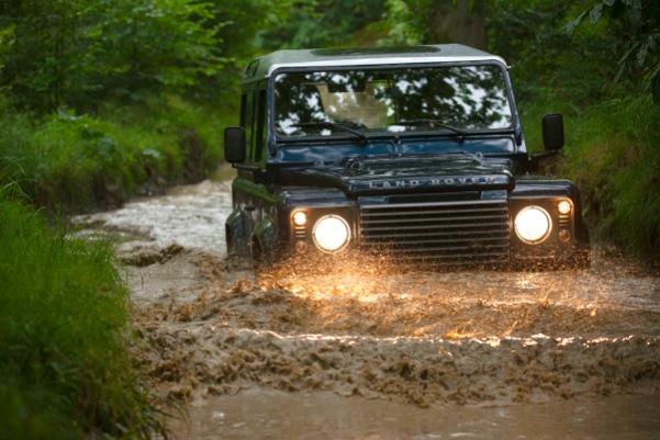 Land Rover Defender in river wading water