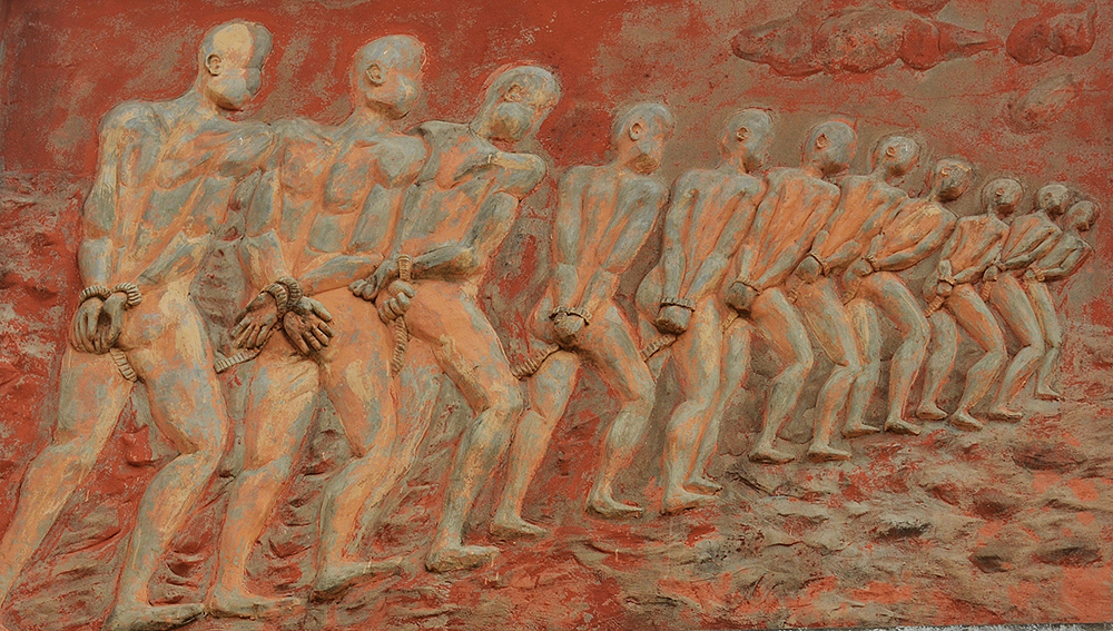 Gate of No Return – Ouidah, Benin: A bas-relief of slaves on the imposing Gate of No Return; it was slaves from here that carried the Voodoo belief system to Haiti, Louisiana, Cuba and Brazil.